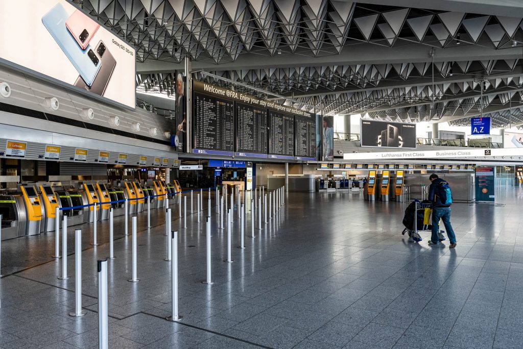 Safe Travel - empty airport showing one passenger traveling to his gate. coronavirus image