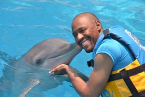 World Footprints co-founder, Ian Fitzpatrick, enjoys a kiss from Dori the dolphin.