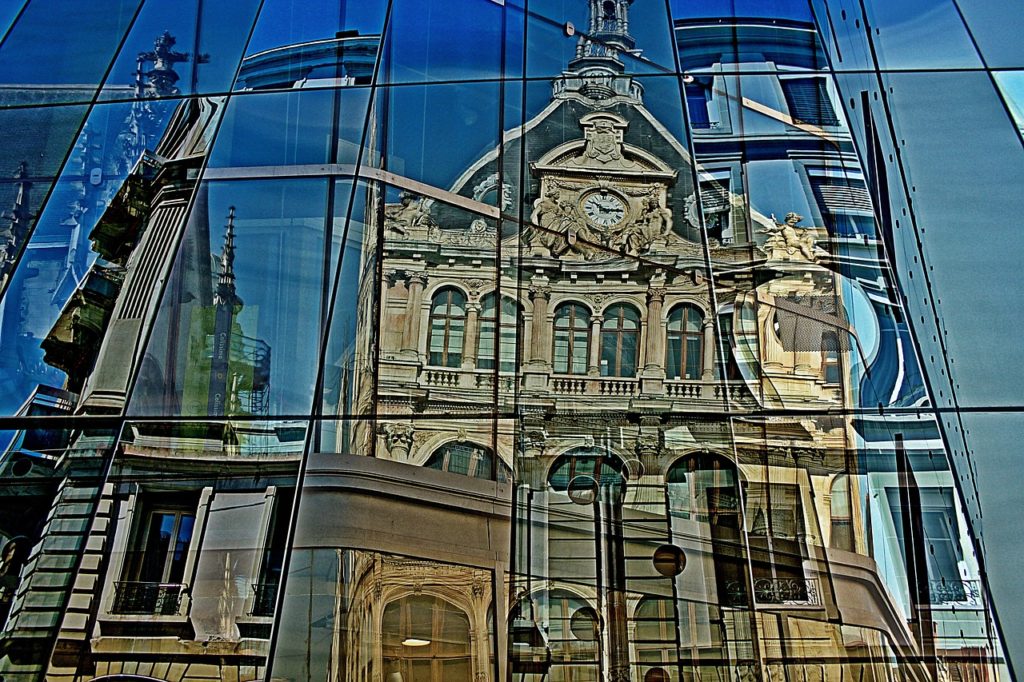 La Tour-de-Salvagny | A historic cathedral reflects off of a modern glass building in Lyon, France.
