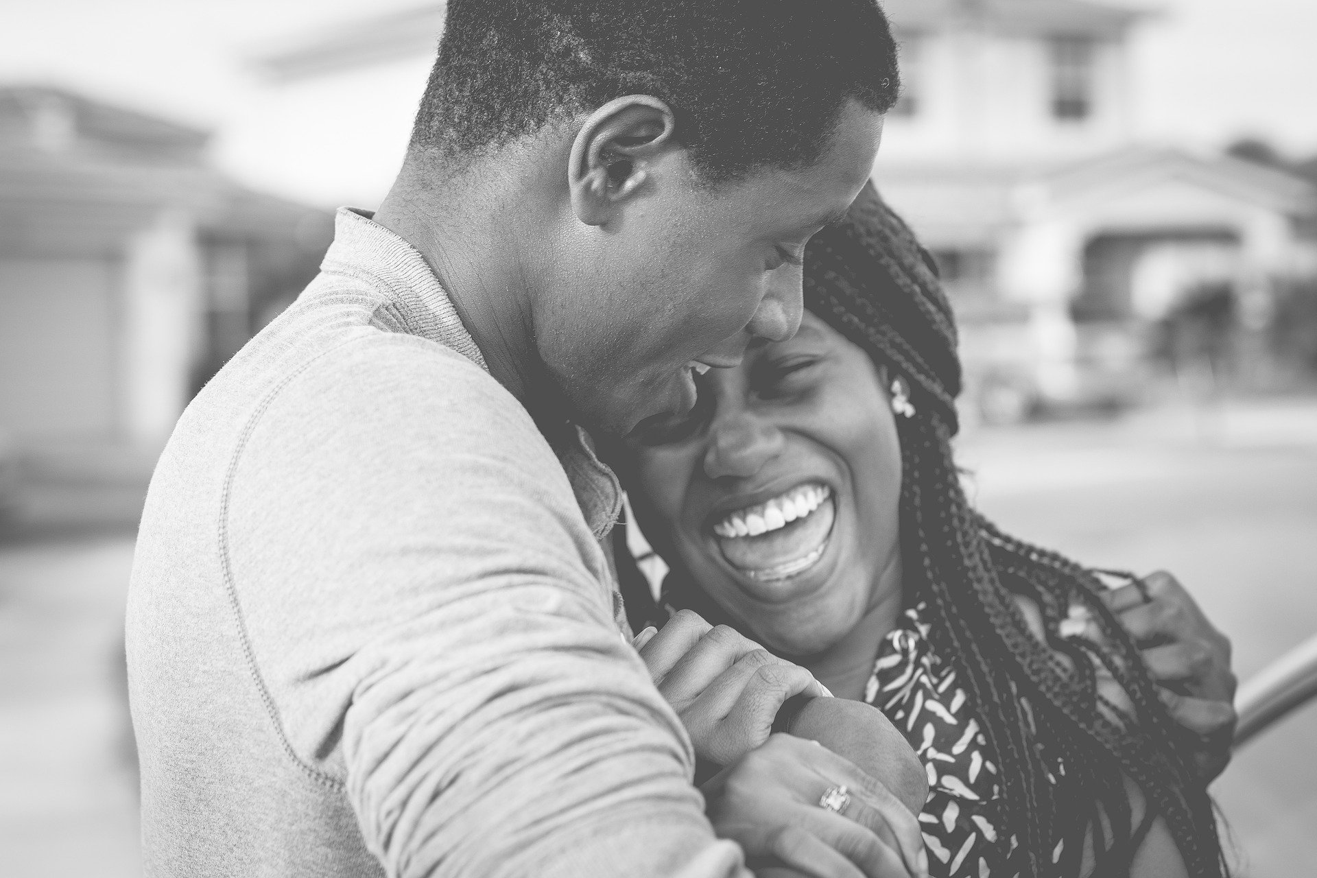 Black couple laughing in bw photo.