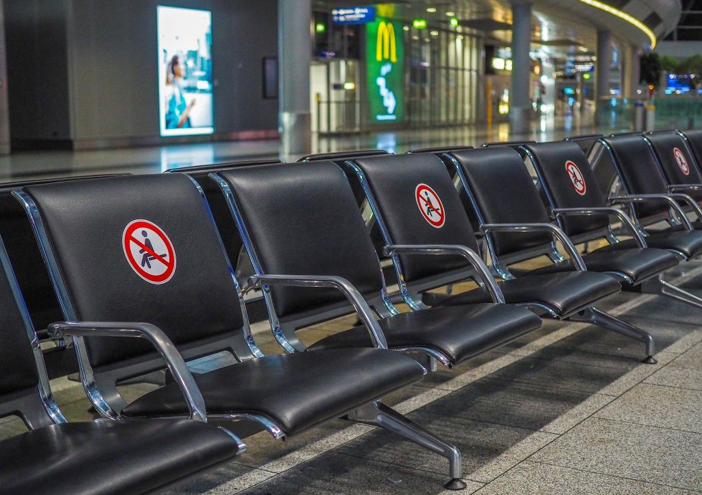 Airport seats in an empty airport. Every other seat is blocked off for social distancing because of COVID