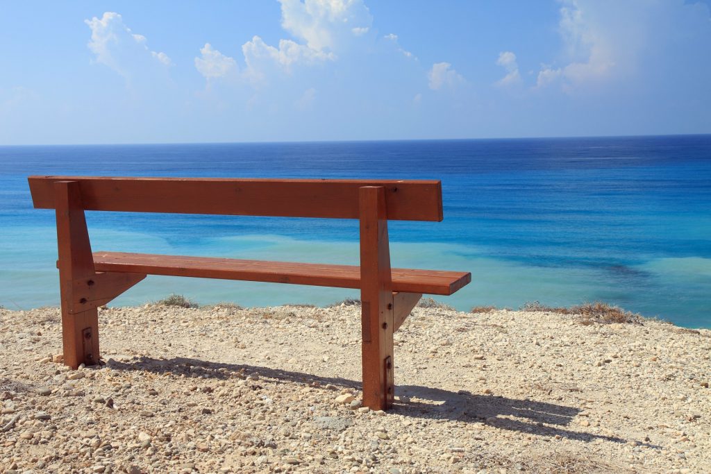 Responsible Travel - Empty bench on the beach