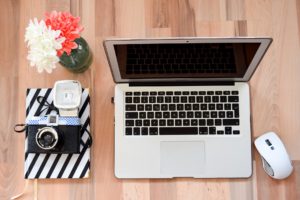 Laptop, camera and journal for freelance writer