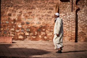 Marrakech - Man walking along the red walls in Marrakesh