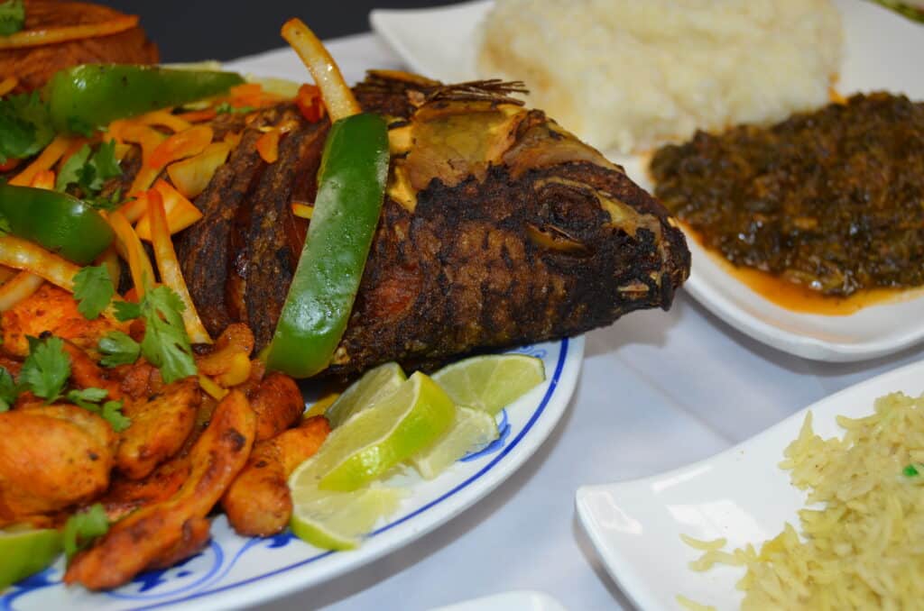 Typical Somali dish of fried whole fish, colorful rice sprinkled with raisins and chapati flatbreads. Photo: Cara Siera