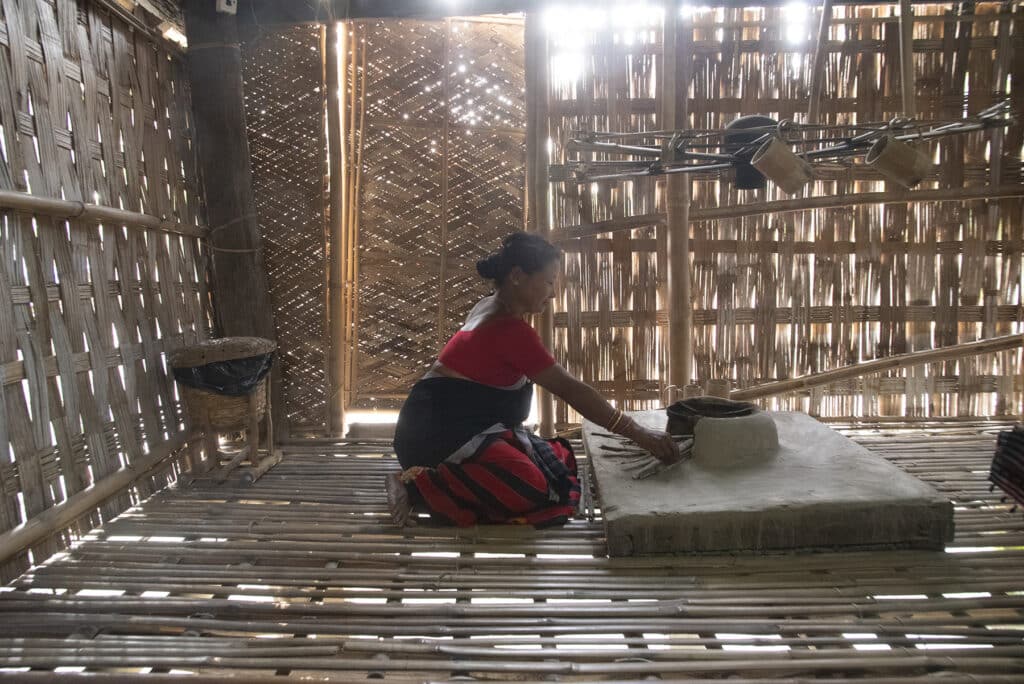 A Mishing lady in her traditional hut. Photo: Sugato Mukherjee