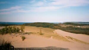 Panorama of Dunes with Sleeping Bear Mama to the right on horizon, two cubs on left in Lake Michigan as seen through the words of Native American folklore