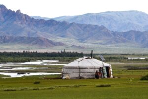 A traditional yurt with a view of Mongolian mountains.