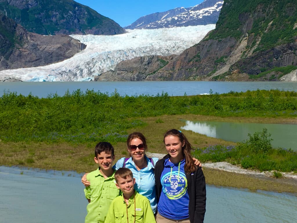 Author and family by Mendenhall Glacier in Alaska. Traveling with kids