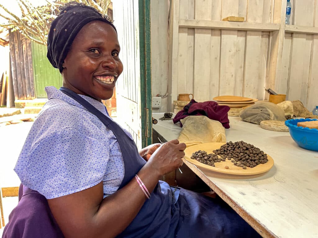 Irene demonstrates rolling clay beads. Kenya. Photo: Julie Dee Suman