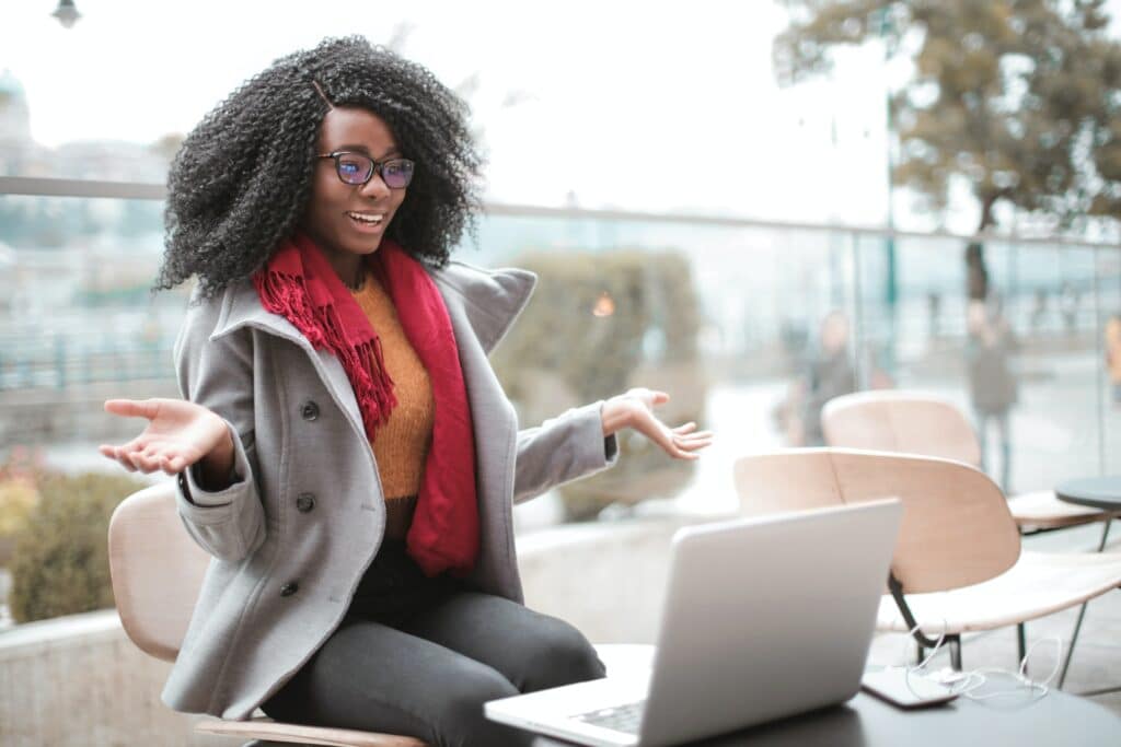 Black female traveler researching travel on computer.