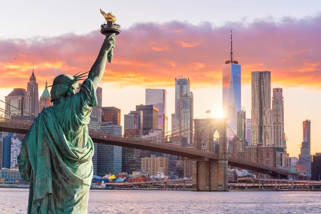 Statue Liberty and New York city skyline at sunset, in United States. Image courtesy of Jacklynn Ann Balderosa