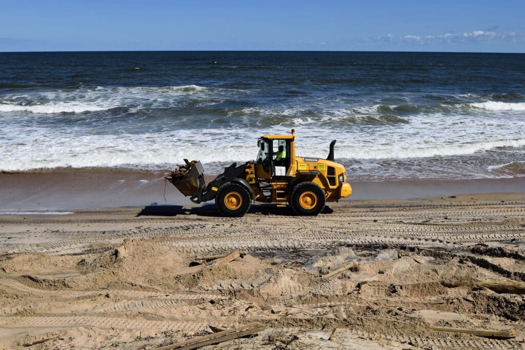 Construction-worker-in-heavy-equipment-cleaning-up-beach-in-florida. voluntourism in panama city