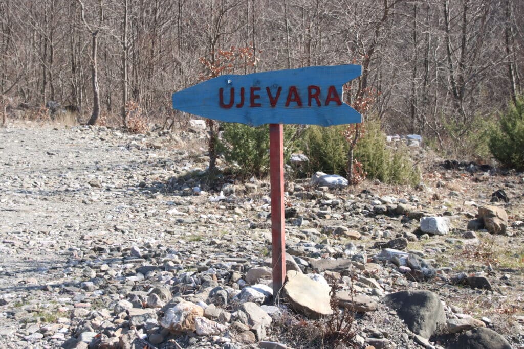 Blue UJEVARA sign pointing towards the hiking trail. Photo: Thomas Später