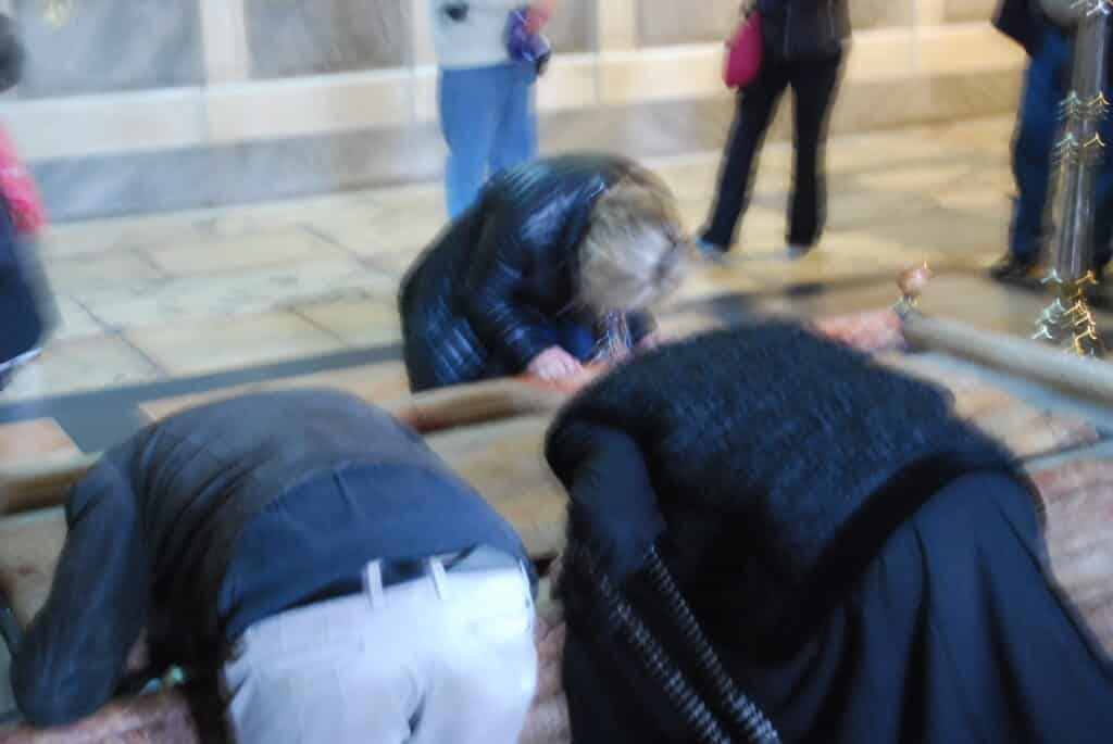 Visitors kneel down to kiss the Stone of Anointing. This is where Jesus' body is said to have been anointed before burial. Photo: Tonya Fitzpatrick