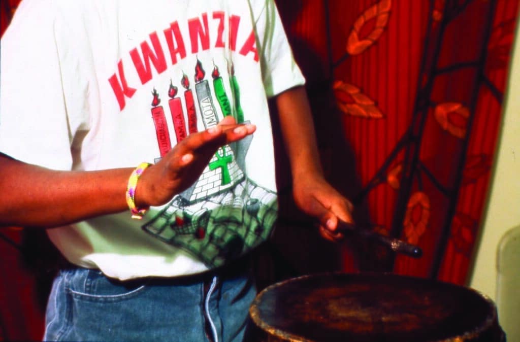 Young man playing drums during Kwanzaa. celebration
